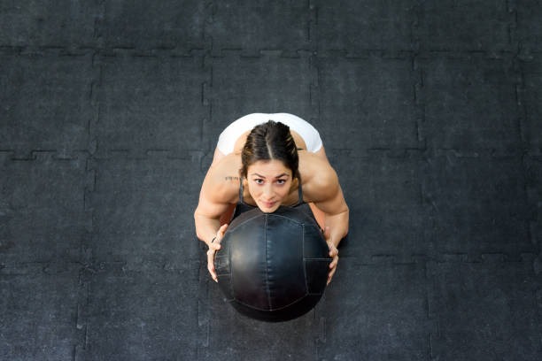 a woman doing a medicine ball exercise