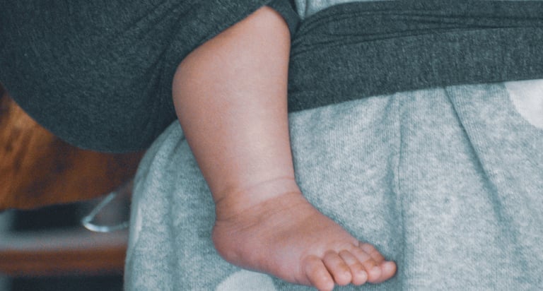 Madre abrazando a su bebé con ternura, vínculo seguro y amoroso