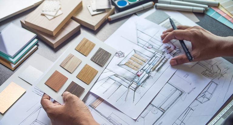 a person is working on a design project with drawings and materials samples