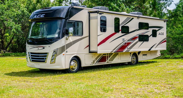 A modern Thor Motor Coach A.C.E. Class A motorhome parked on grass with a slide-out extended.