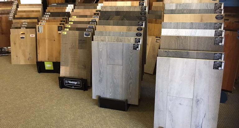 Flooring showroom displaying hardwood, laminate, tile, and vinyl flooring options.