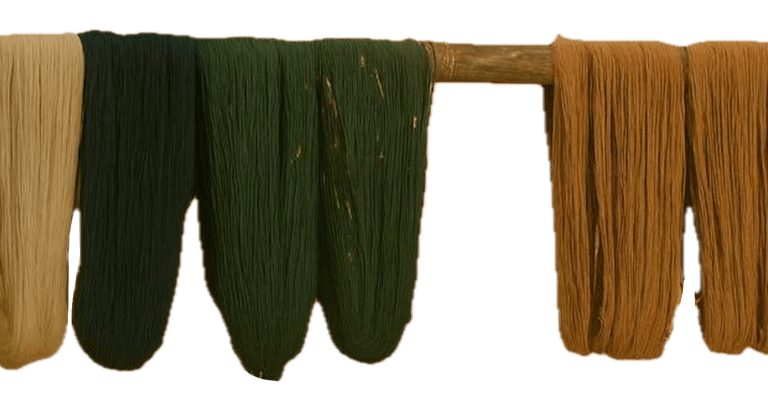 Hand- dyed wool yarns drying on a wooden frame