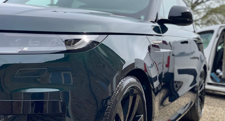 a black range rover parked in graveled area