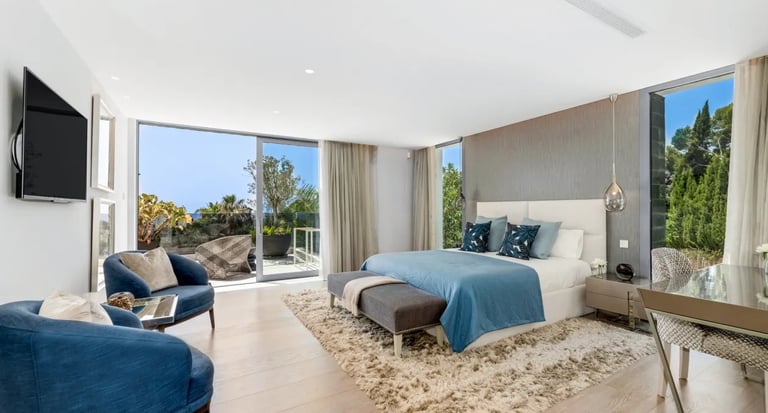 Elegant suite at Villa Serenity with blue chairs and sea outlook