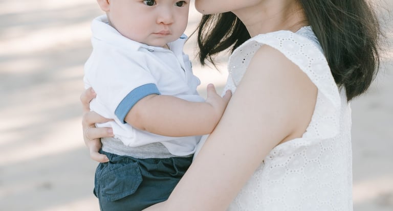 Mother holding baby outdoors at Intercontinental Jimbaran during a calm and natural Bali family photography session