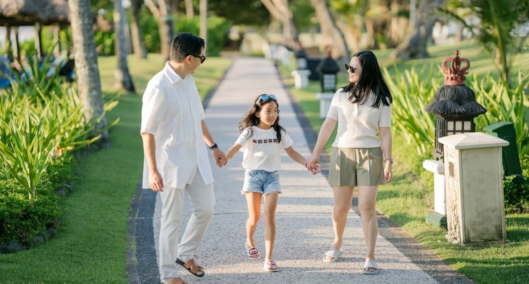 Family walking along a garden pathway during a family photography session at InterContinental Bali Resort