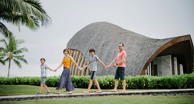 Family photography session walking beside the oceanfront chapel at The Apurva Kempinski Bali