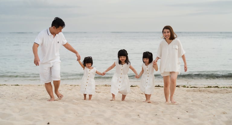 Family walking together along the shoreline at The Mulia Nusa Dua Bali during a sunset family photography session