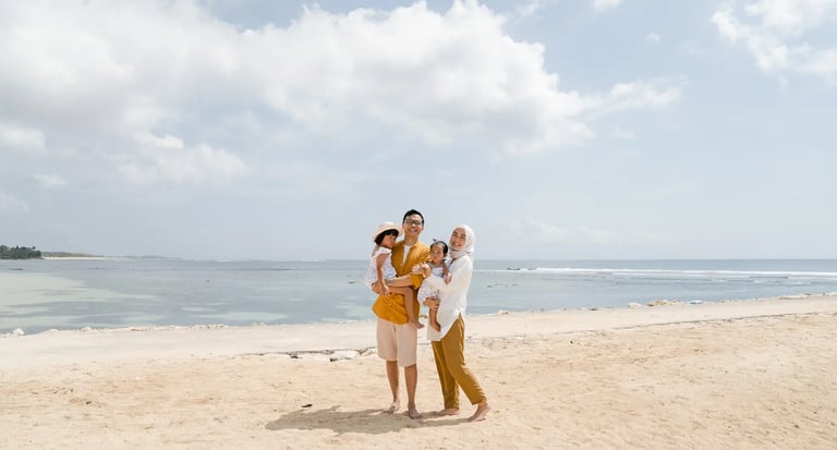 Family portrait by the shoreline at The Apurva Kempinski Bali beach