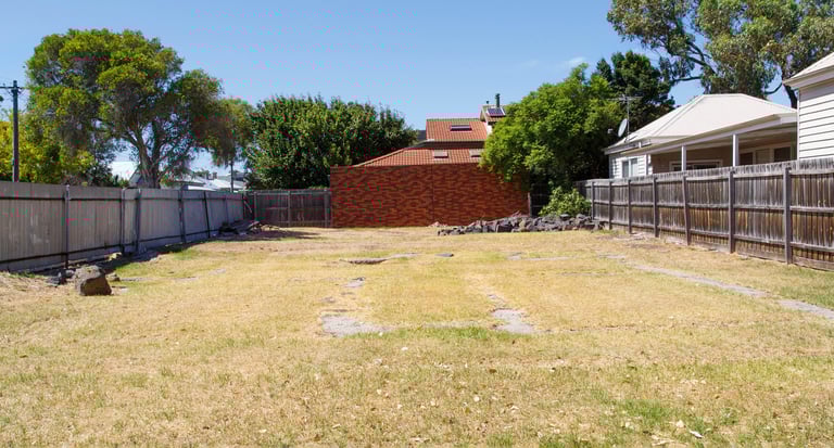 Dry yard with wooden fence and shed