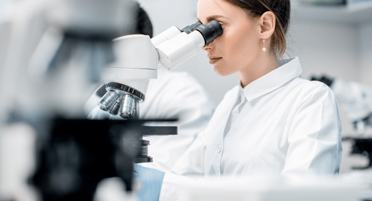 Naukowiec analizujący próbki pod mikroskopem w laboratorium badawczym.