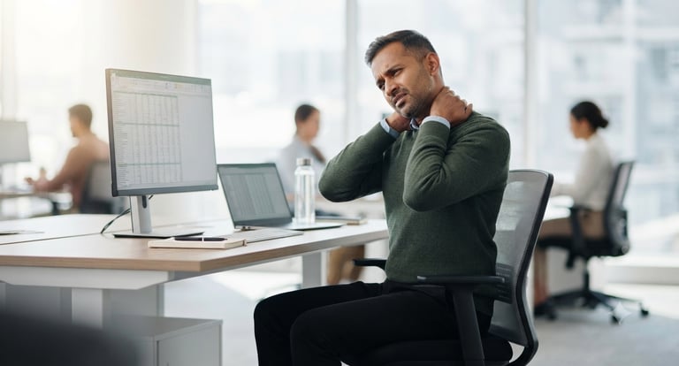 Office worker experiencing neck and shoulder discomfort after extended computer use.