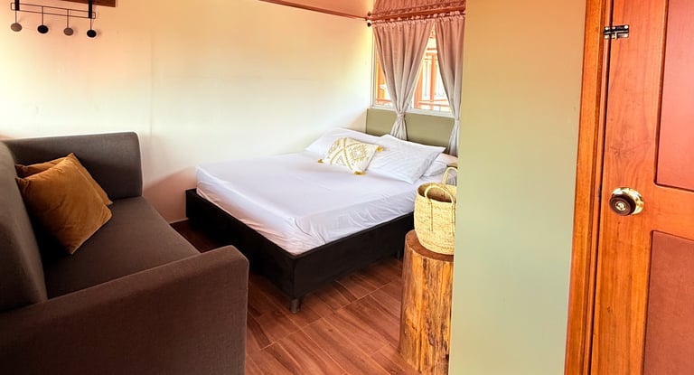 Habitación con cama doble, sofá, con ventanas