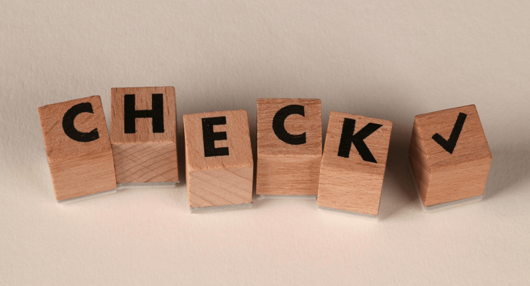 Blokjes met letters C-H-E-C-K en een vinkje als symbool voor korte reflectie en checkmoment.
