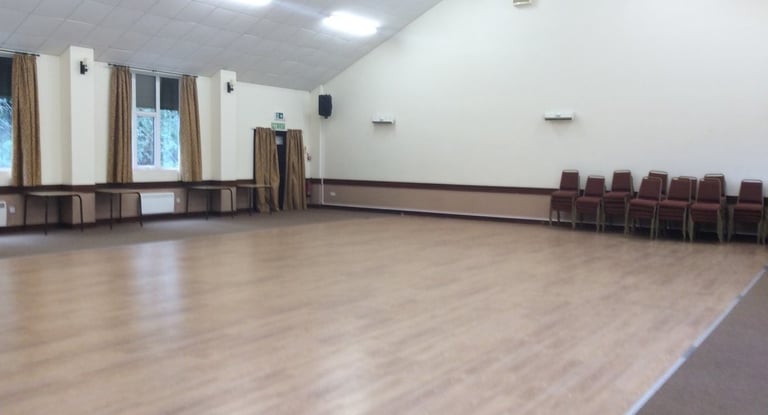 a room with a large wooden floor and a large window