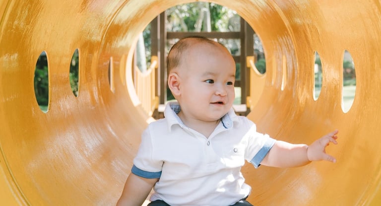 Baby sitting inside playground slide at Intercontinental Jimbaran during a natural lifestyle family photography session