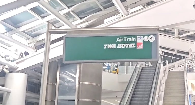 JFK terminal sign pointing to AirTrain and TWA Hotel