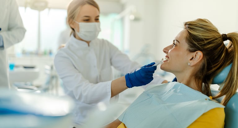 A professional dentist performing a dental checkup on a female patient in a modern dental clinic.