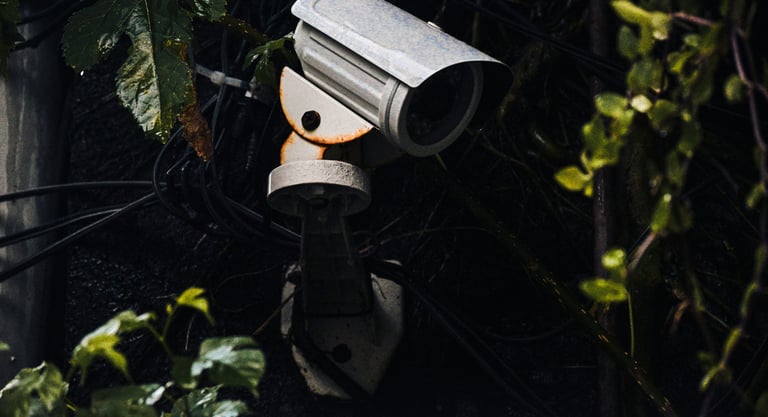 Una cámara de seguridad exterior antigua montada en una pared