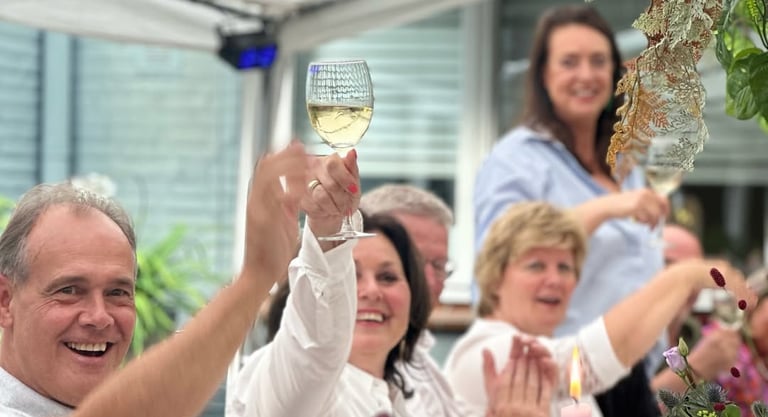 Mensen proosten tijdens een luxe verjaardagsdiner aan huis, verzorgd door Xagis Catering.