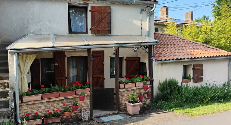 a house with a red roof and a white house with red flowers