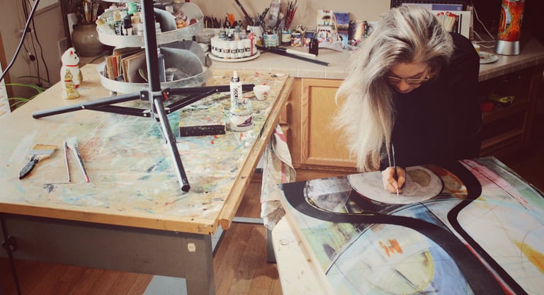 Artist Robin Arthur painting an abstract in her Paonia, Colorado studio