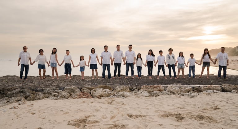 Large family standing together in a line on the beach during sunset at The Ritz-Carlton Bali Nusa Dua