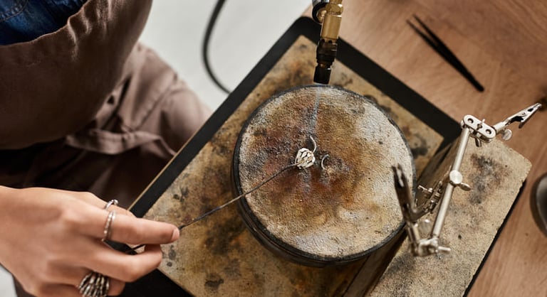 Creador de joyería con soplete de soldadura para elaborar un anillo de plata