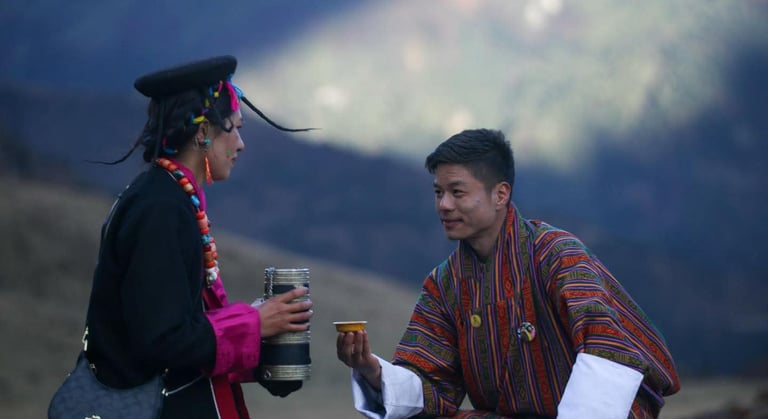 Layap-women-in-Bhutan-with-a-traditional-gesture-of-welcoming-a-guest-serving-local-wine-ara