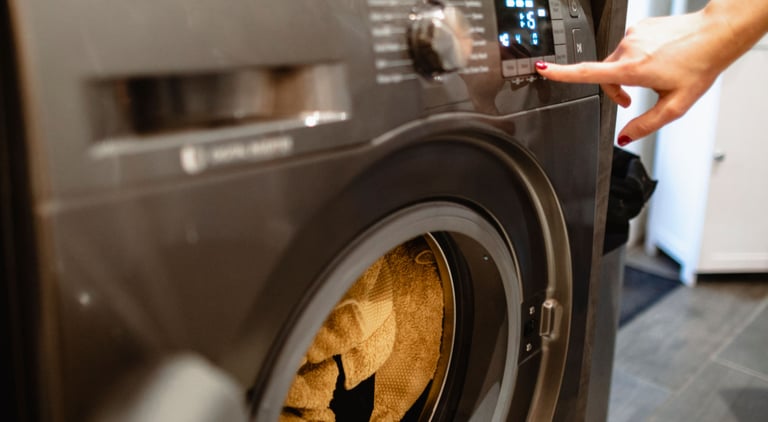 a person is putting a towel in a washing machine