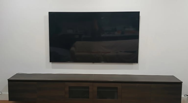 Space-saving ultra slim TV wall mounting for a compact apartment living room in Melbourne CBD.