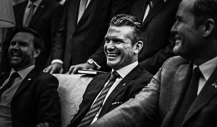 a man in a suit and tie smiling at the camera