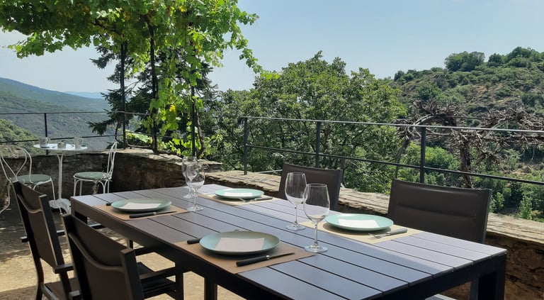 Vue de la terrasse avec table à manger au gîte la Petite Corse à Rosis