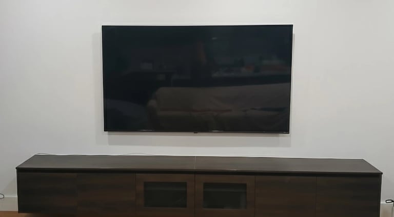 Space-saving ultra slim TV wall mounting for a compact apartment living room in Melbourne CBD.