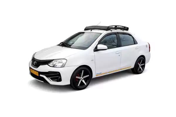 White Toyota Etios one way taxi by Saini taxi services with a luggage carrier rack