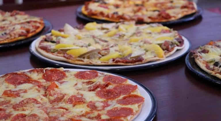 Imagen de pizzas en una mesa