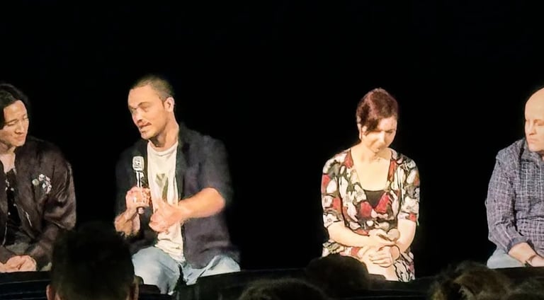 a man and woman sitting on a stage with microphones