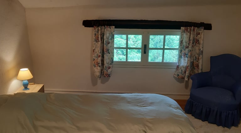 Chambre à coucher avec vue extérieur du gîte la Petite Corse à Rosis dans le Haut-Languedoc