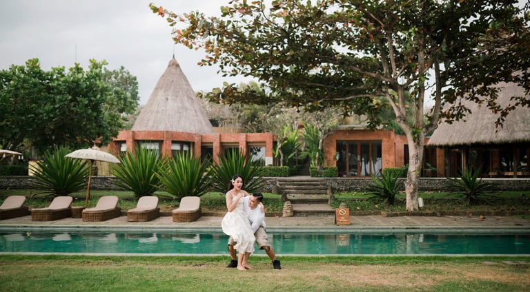 Couple standing by the pool at Waka Gangga Tabanan surrounded by tropical architecture in West Bali