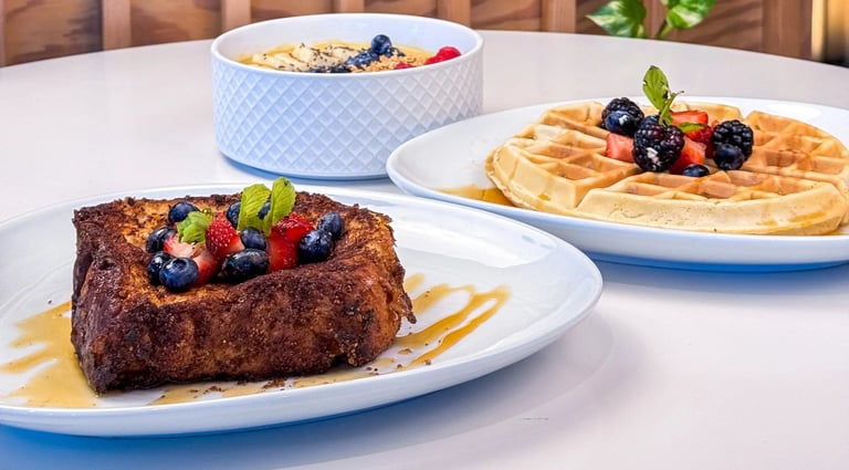 a table with a plate of food and a bowl of fruit