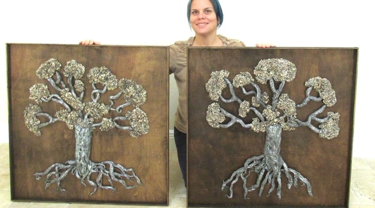 visual artist holding sculpture of trees