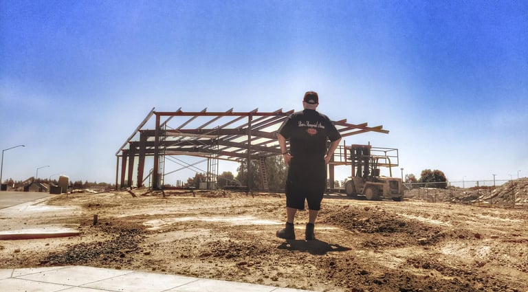 a man standing in front of a building under construction