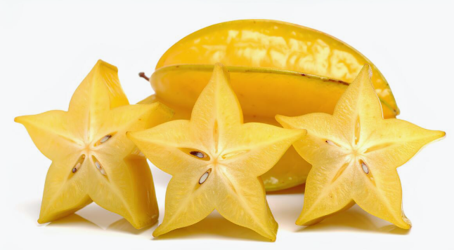 Fresh yellow star fruit slices and a whole carambola isolated on a white background.