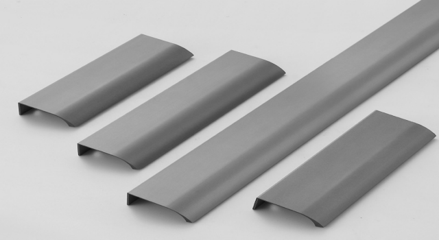 Multi-finish aluminum minimalist handles displayed against a white background, showcasing sleek arc design.