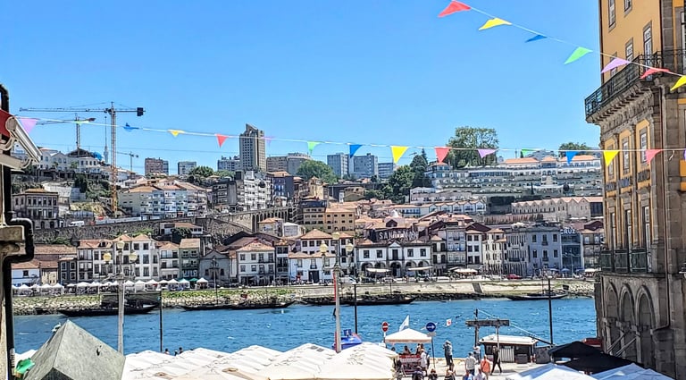 Colorful houses along the Douro River in Porto, Portugal, with reflections on the blue water and his
