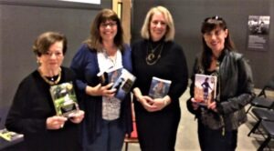 a group of women holding books and posing for a picture