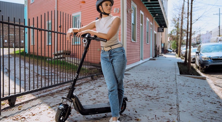 a woman in a helmet and helmet on a scooter