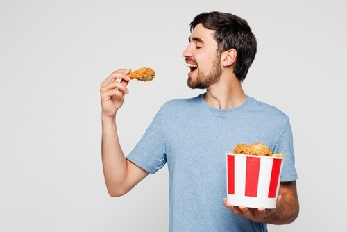 a man eating a fried chicken nuggies