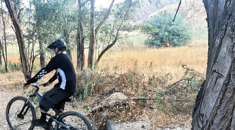mountain biker landing wheelie drop with level pedals and both wheels touching down smoothly
