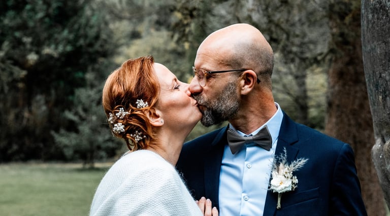 Un couple s'embrassant en tenue de mariés